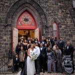 Breena and Bradley after their wedding in front of a church with whole family